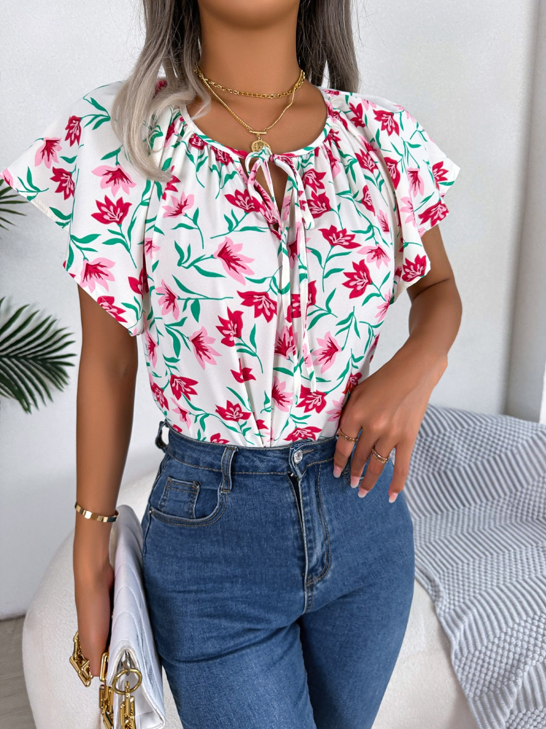 Blusa floral con cuello anudado y mangas acampanadas