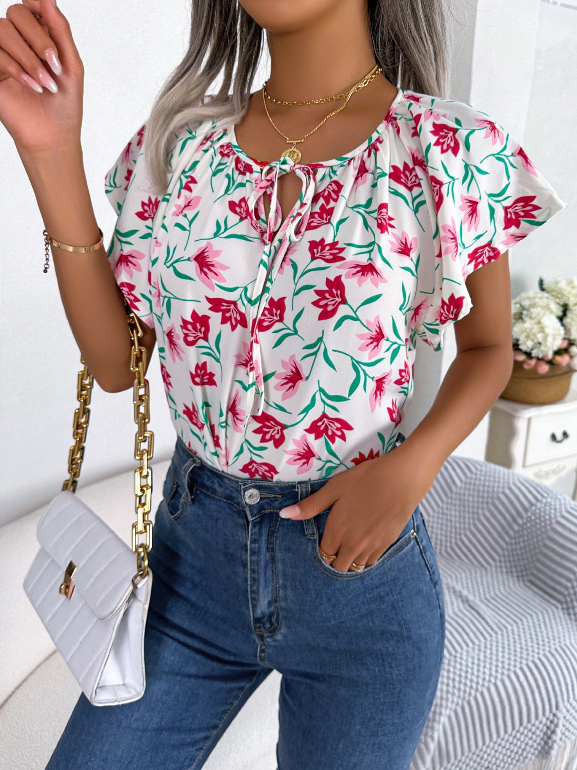 Blusa floral con cuello anudado y mangas acampanadas