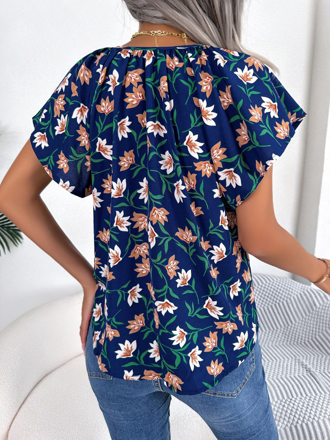 Blusa floral con cuello anudado y mangas acampanadas