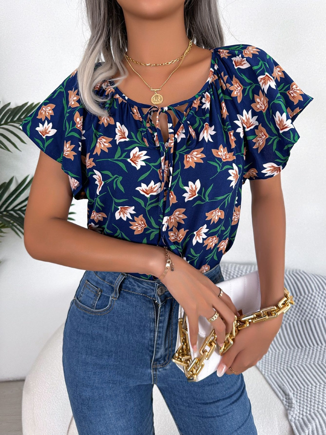 Blusa floral con cuello anudado y mangas acampanadas