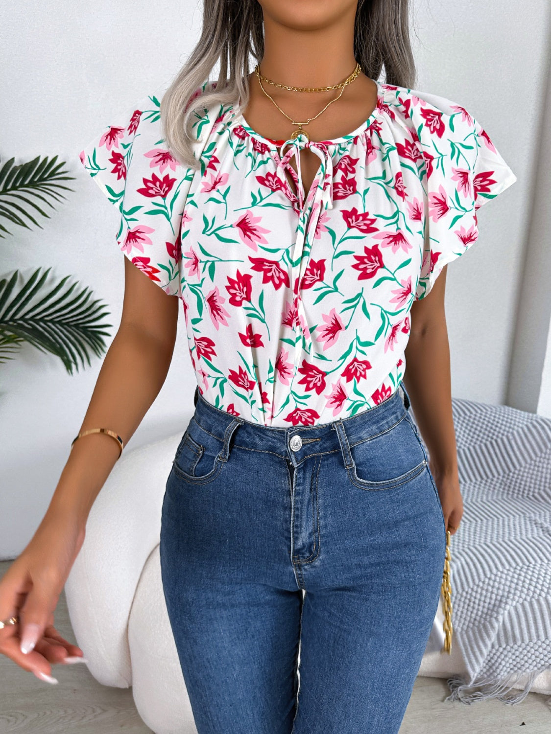 Blusa floral con cuello anudado y mangas acampanadas