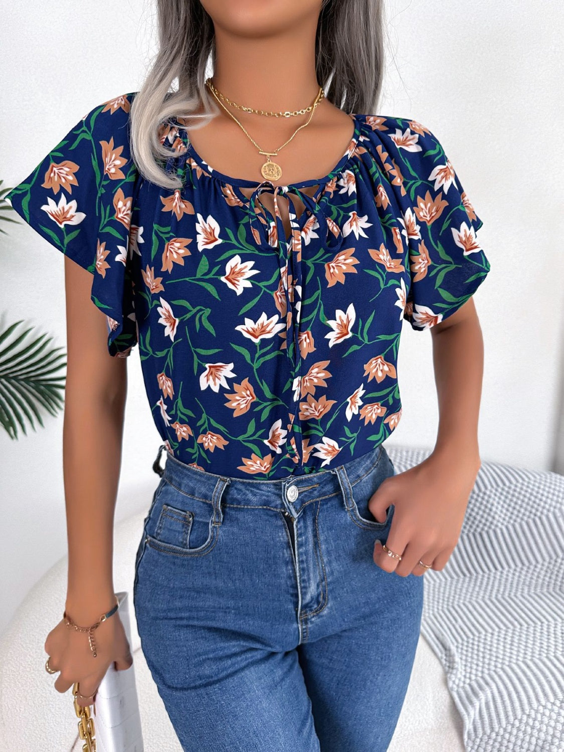 Blusa floral con cuello anudado y mangas acampanadas