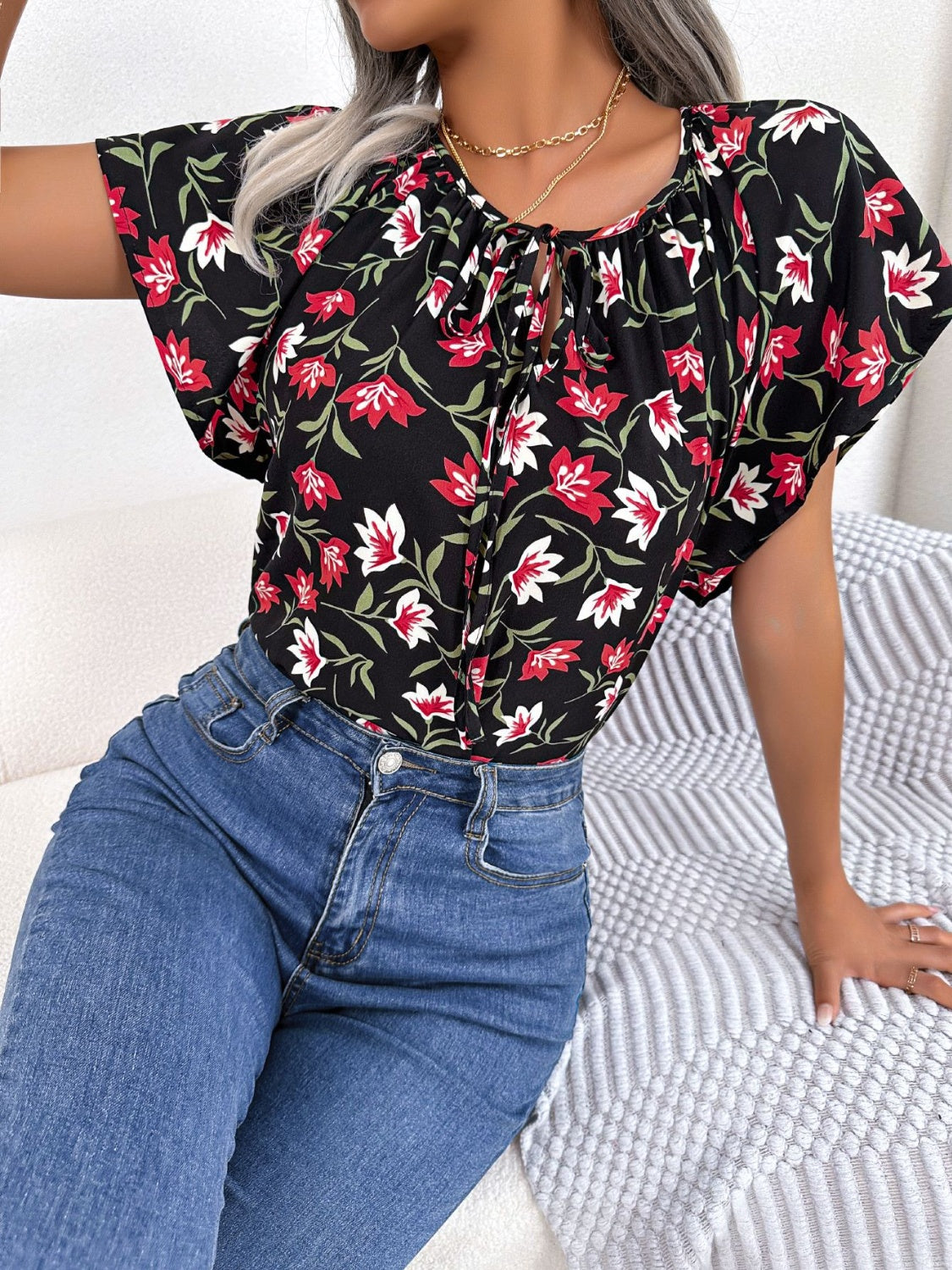 Blusa floral con cuello anudado y mangas acampanadas