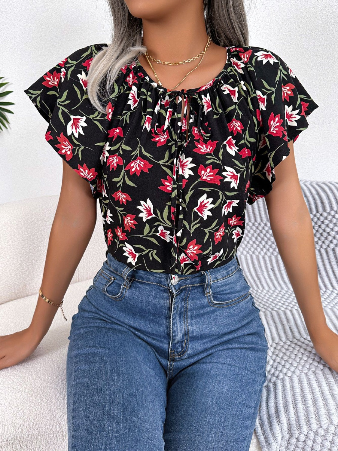 Blusa floral con cuello anudado y mangas acampanadas