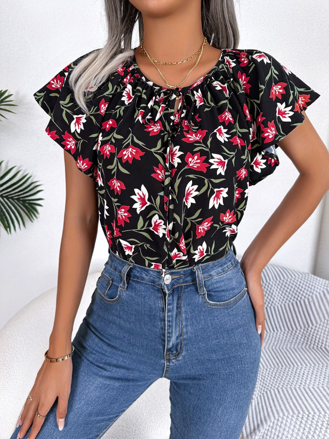 Blusa floral con cuello anudado y mangas acampanadas