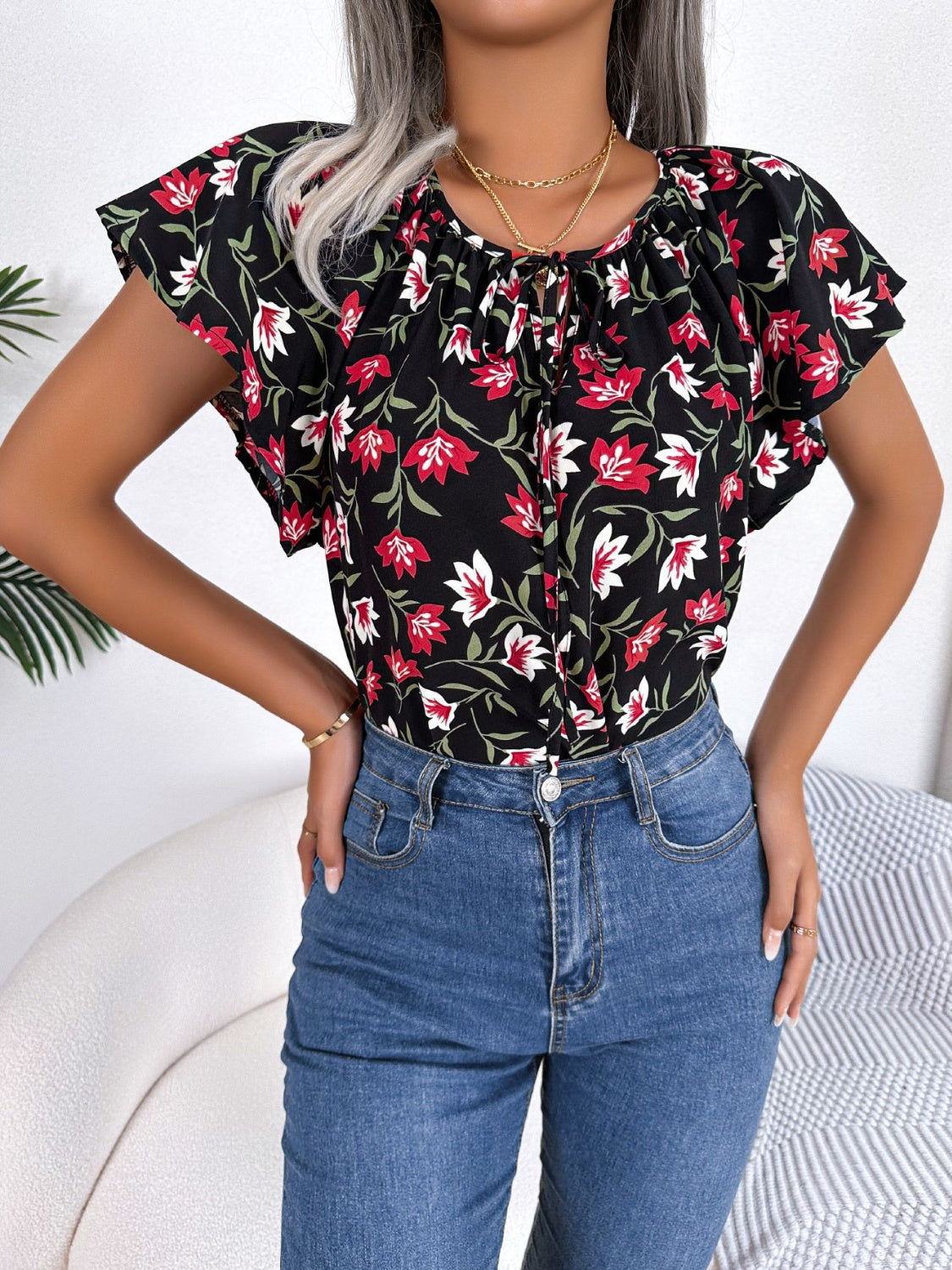 Blusa floral con cuello anudado y mangas acampanadas