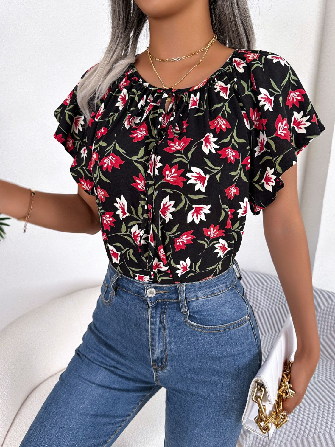 Blusa floral con cuello anudado y mangas acampanadas