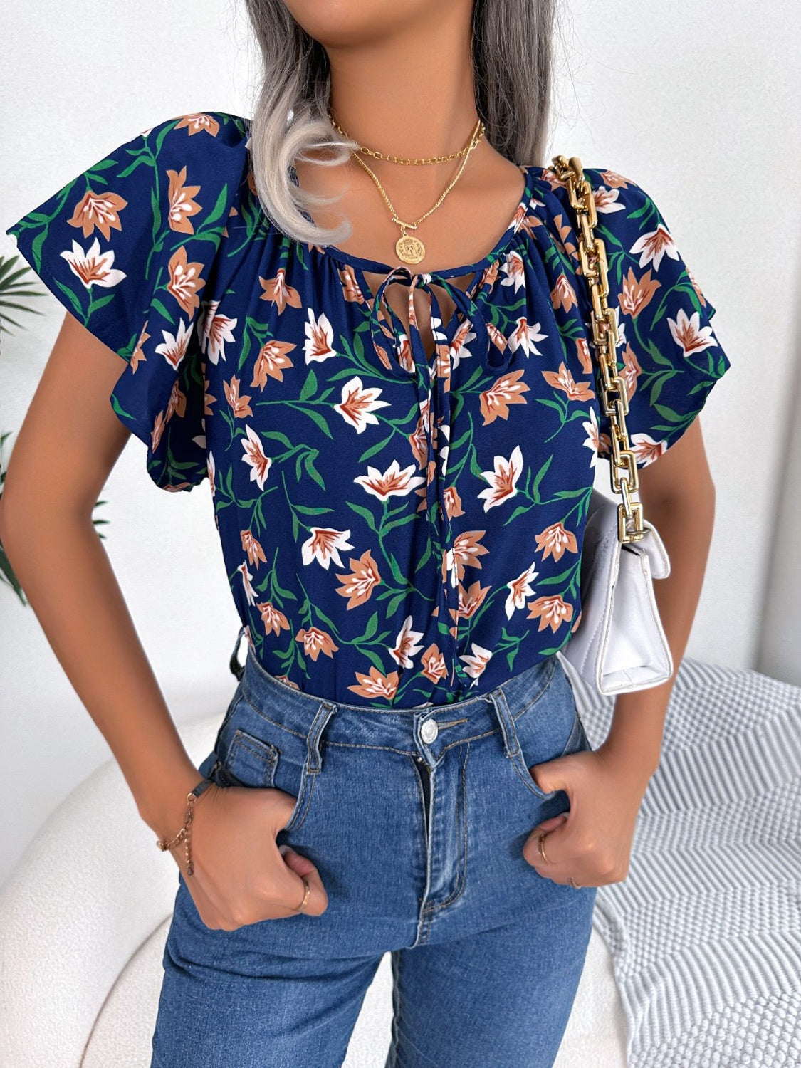 Blusa floral con cuello anudado y mangas acampanadas