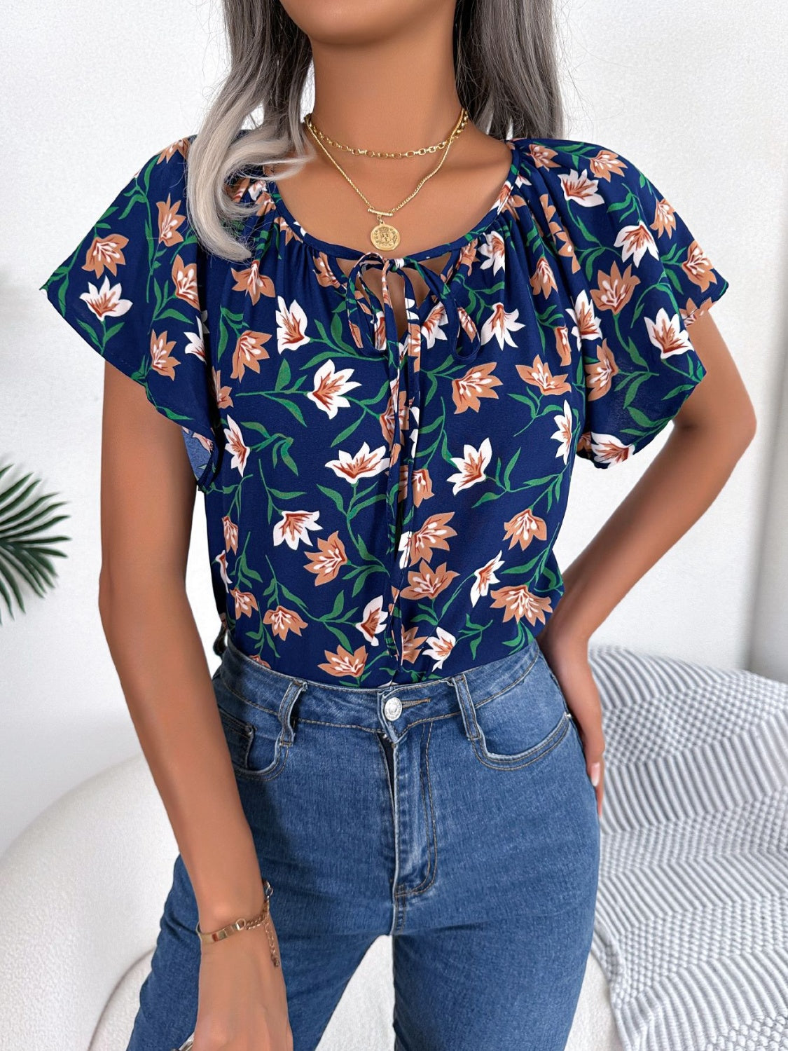 Blusa floral con cuello anudado y mangas acampanadas