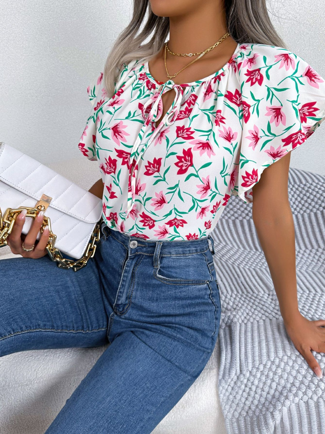 Blusa floral con cuello anudado y mangas acampanadas